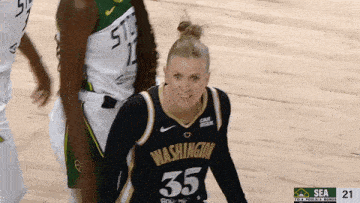 a woman wearing a washington jersey number 35 is smiling