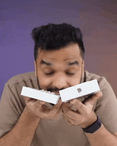 a man with his eyes closed is holding a white apple box