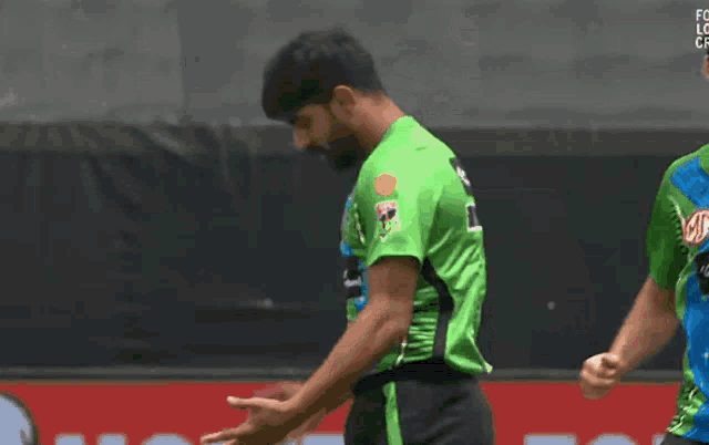 a man in a green and blue jersey with a md logo on his hat