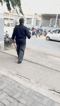 a man is walking down a street holding a sword .