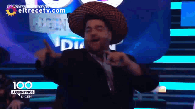 a man in a sombrero is dancing in front of a 100 argentinas dicen sign