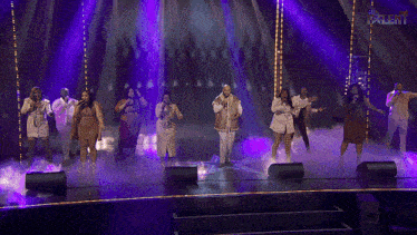 a group of people singing on a stage with the word talent on the bottom left