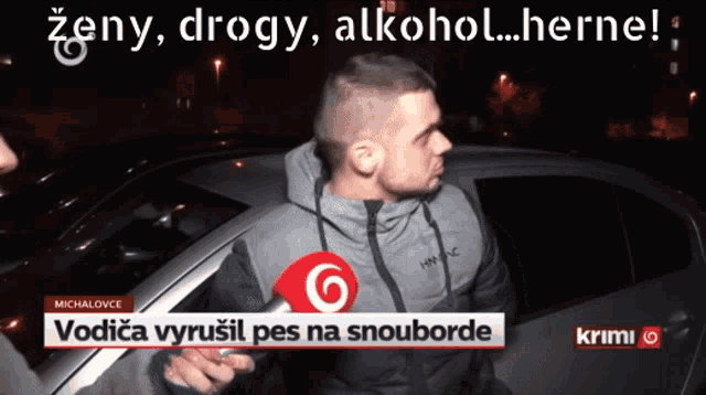 a man talking into a microphone in front of a car that says zeny drogy alkohol herne