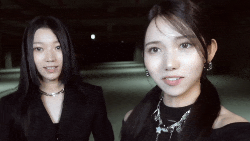 two women are standing next to each other and one is wearing a necklace that says " i love you "
