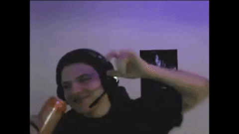 a man wearing headphones and a microphone is dancing in front of a purple wall .
