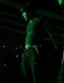 a man singing into a microphone on a stage with a belt that says ' a ' on it