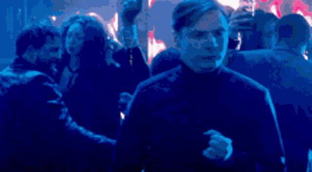 a man is dancing in front of a crowd of people in a club .