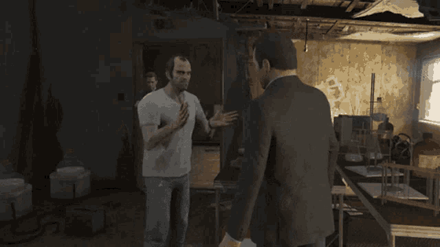 a man in a suit and white shirt is talking to another man in a room