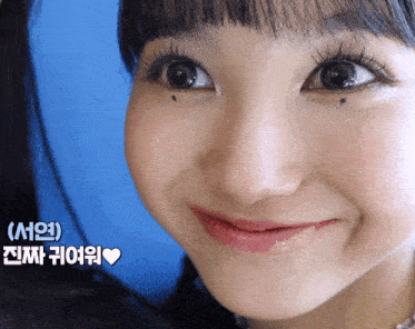 a close up of a woman 's face with a heart in the lower right corner