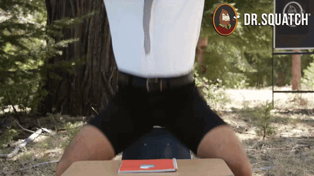 a man squatting on a box with dr.squatch written on the bottom