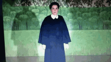 a woman in a blue dress and white gloves is standing in front of a green background