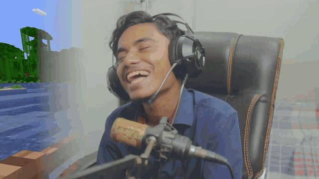 a young man wearing headphones and a microphone laughs