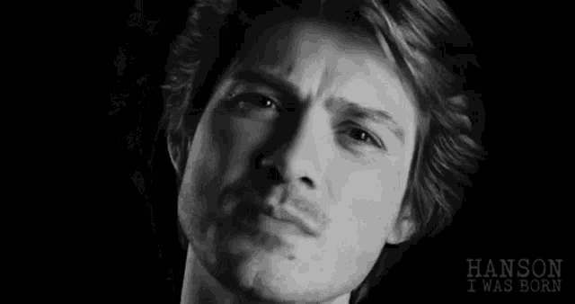 a close up of a man 's face in a black and white photo with the words `` hanson i was born '' .
