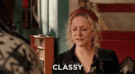 a woman is sitting in a chair with her eyes closed and the word classy written on the screen behind her .
