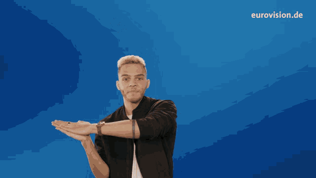 a man stands in front of a blue background that says " we are rocks "