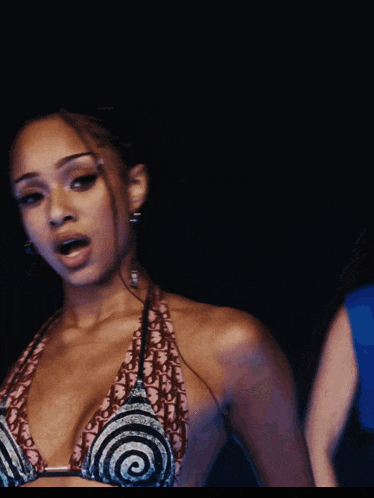 a woman wearing a braided ponytail and earrings has a ring on her finger that says always