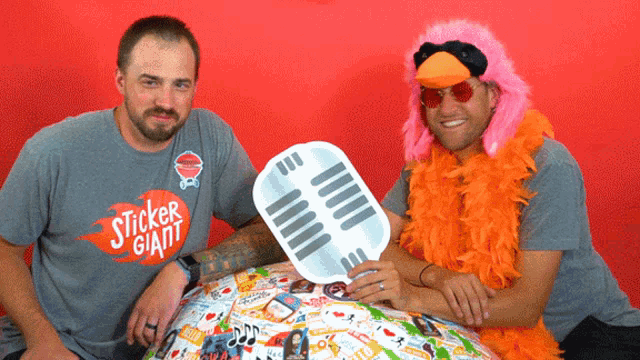 a man in a sticker giant shirt sits next to another man