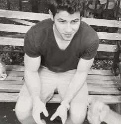 a man in a black shirt is sitting on a park bench