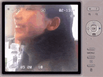 a video camera is recording a woman 's face with the date 02-13 on the screen