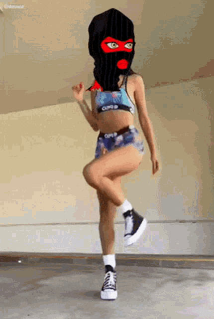 a woman wearing a ski mask and shorts is dancing in a garage