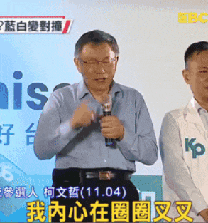 a man is holding a microphone in front of a sign that says ' his '