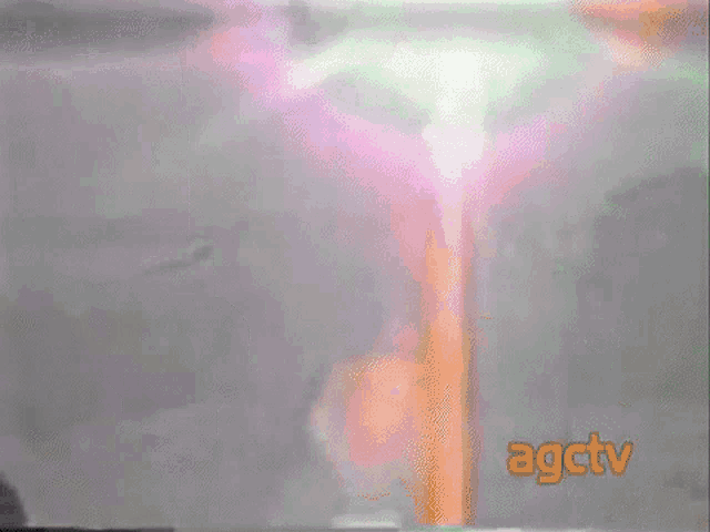 a tv screen shows a statue of jesus on a cross and the words agctv