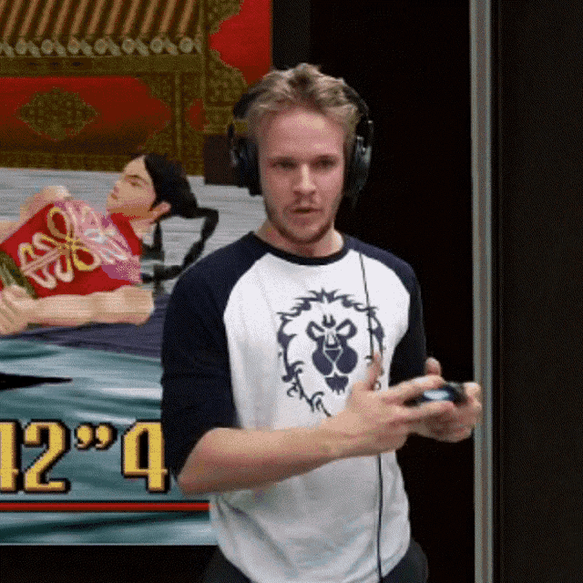 a man wearing headphones holds a controller in front of a sign that says 12 '4