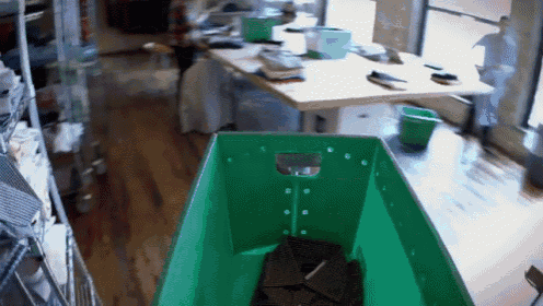 a green crate filled with pieces of chocolate sits on the floor