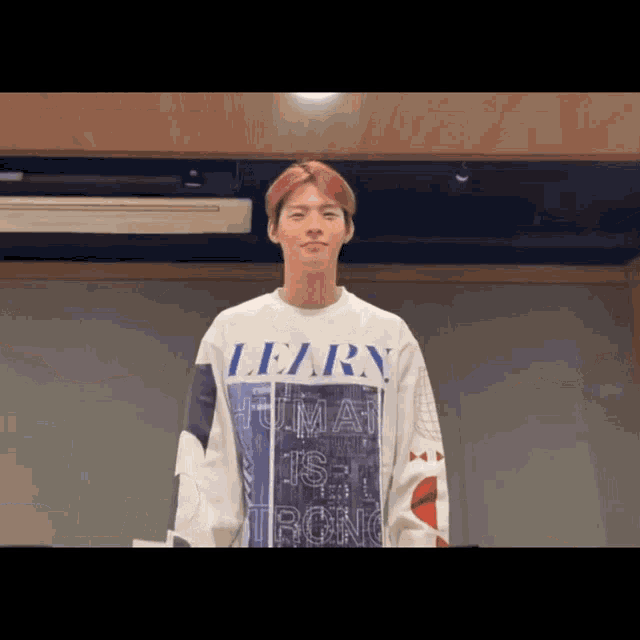 a man wearing a white sweater that says learn on it