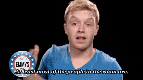 a man wearing a blue shirt and a button that says emmys