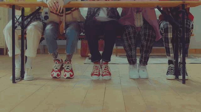 a group of people sitting at a table with their legs crossed and their shoes on