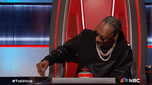 snoop dogg is sitting in a chair with a nbc logo on the bottom
