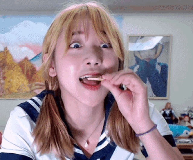 a woman with pigtails is eating something with a cigarette in her mouth