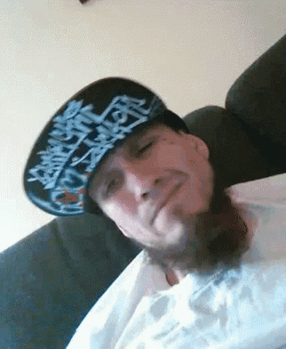 a man wearing a hat with graffiti on it is smiling