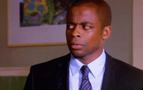 a man in a suit and tie looks to the side