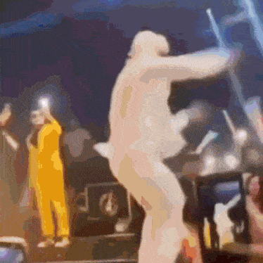 a blurry picture of a man in a yellow suit dancing on stage