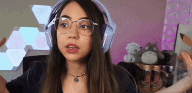 a woman wearing glasses and headphones is making a face