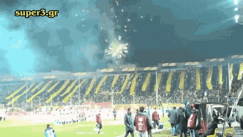 a super3.gr logo is displayed above a crowd of people on a soccer field