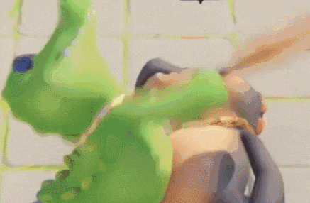a close up of a green frog laying on its back on a white surface .