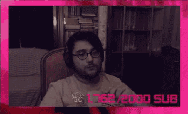 a man wearing glasses and a shirt that says " quantum " is sitting in a chair