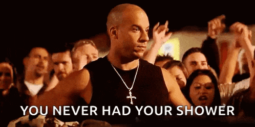 a bald man is standing in front of a crowd of people .