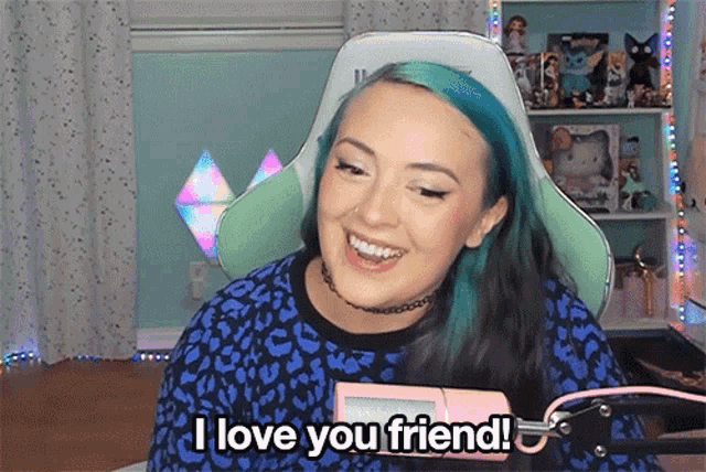 a woman with blue hair says i love you friend in front of a microphone