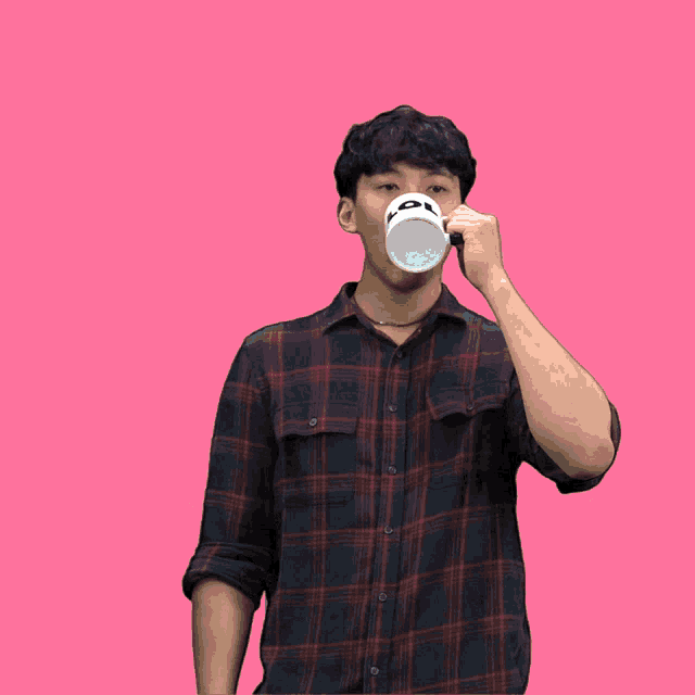 a man in a plaid shirt is drinking from a straw with a star on it