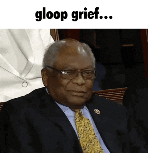 a man in a suit and tie is sitting in front of a sign that says " gloop grief "