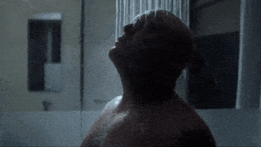a man is taking a shower and looking up at the sky