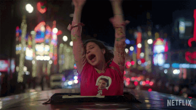 a woman with her arms in the air is sitting in the back of a netflix car