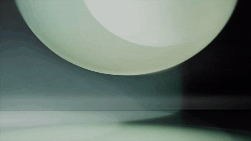 a white sphere is floating in the air on a black background