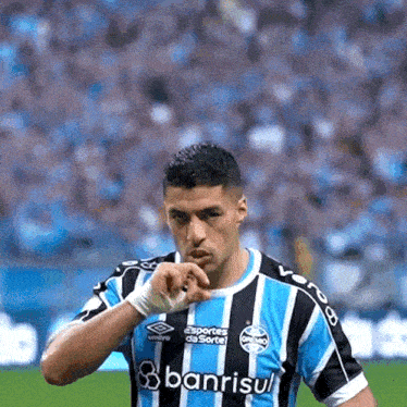 a soccer player wearing a blue and black striped shirt with banrisul on it