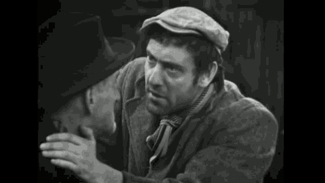 a man in a hat is touching the face of another man