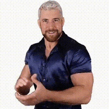 a man with a beard is wearing a blue shirt and making a funny face .